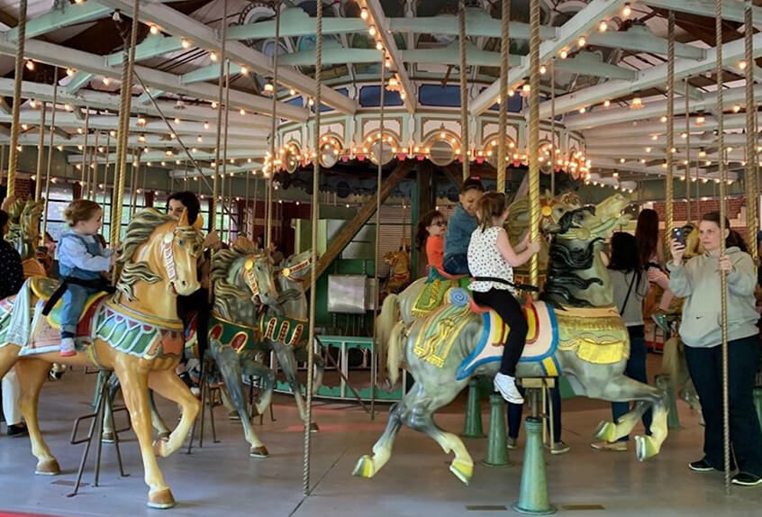 Lower school students riding on a carousel