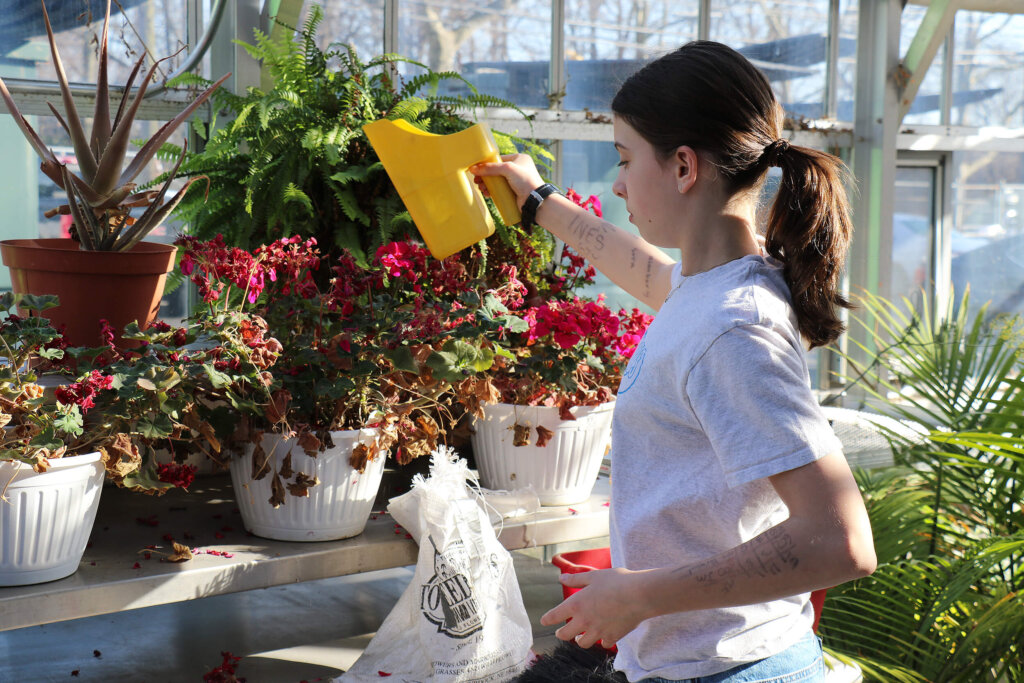 Urban Farming student watering flowers